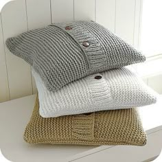 three knitted pillows stacked on top of each other