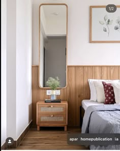 a bedroom with wood paneling and a mirror on the wall next to a bed