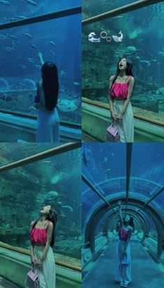 a woman standing in front of an aquarium looking up at the water and holding onto her purse