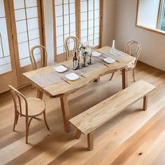 a wooden table with two benches in front of it and vases on the table