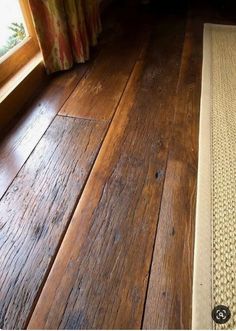 a wooden floor with a rug on top of it next to a window sill