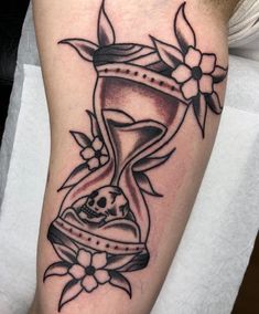 a black and white tattoo on the arm of a man with an hourglass in it