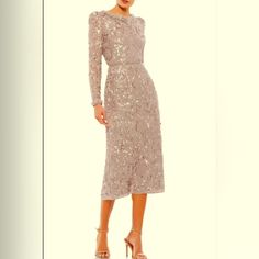 a woman is wearing a dress with long sleeves and a high neckline that has sequins on it