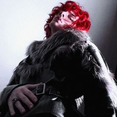 a woman with red hair wearing a fur coat