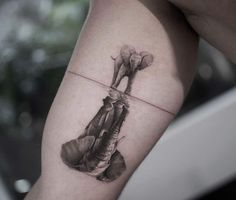 a black and white photo of an elephant's leg with flowers on the side