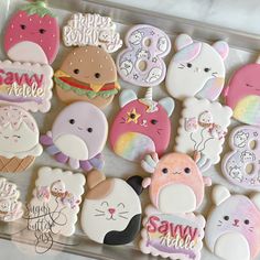 many decorated cookies are on a tray with the words happy birthday written in it and some animals