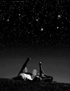 two people laying on the ground under stars