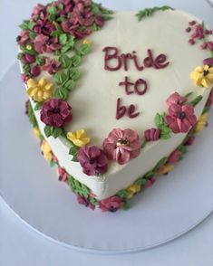 a heart shaped cake decorated with flowers and the words bride to be