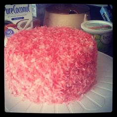 a pink cake sitting on top of a white plate