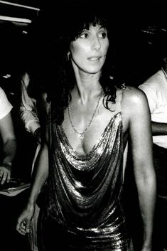 a black and white photo of a woman wearing a dress with sequins on it