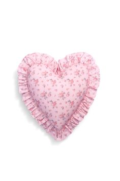 a pink heart shaped pillow with ruffles on the sides and a flower pattern