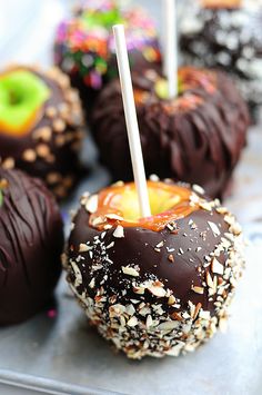 chocolate covered apples with sprinkles and candy sticks