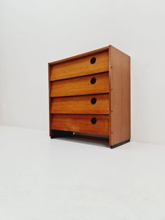 a wooden dresser sitting on top of a white floor