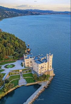 an aerial view of a mansion on the water