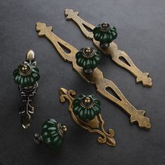 some green and gold items are laying on the table together, including two door knobs