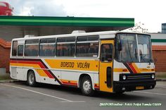 a yellow and white bus parked in a parking lot