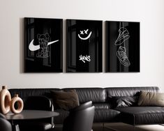 three black and white paintings hang on the wall above a couch in a living room