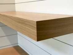 a close up of a shelf in a room with white tile and wood paneling