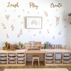 an organized playroom with lots of toys and storage bins on the floor next to a wall that says laugh play create