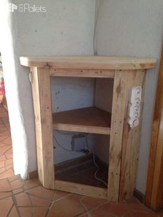 a small wooden cabinet sitting on top of a tile floor next to a white wall