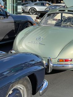 an old car is parked next to other cars