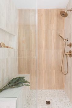 a walk in shower sitting next to a tiled wall