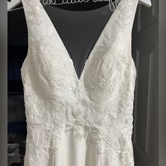 a white wedding dress hanging on a hanger