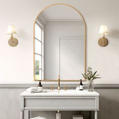 a bathroom with a sink, mirror and two lights on the wall next to it