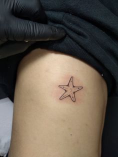 a small starfish tattoo on the thigh