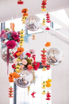 a chandelier filled with disco balls and flowers hanging from it's ceiling