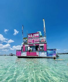 a pink and white food stand in the middle of clear blue water