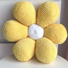 a yellow stuffed flower sitting on top of a white chair