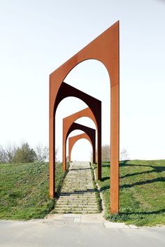 an arch in the middle of a grassy field