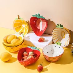 various bowls and fruits are arranged on a yellow surface