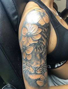 a woman with a tiger and flowers tattoo on her arm