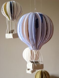 three paper hot air balloons hanging from strings