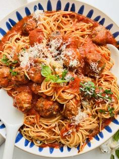 a plate of spaghetti with meatballs and parmesan cheese