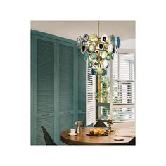 a chandelier hanging over a table in a room with shutters and windows