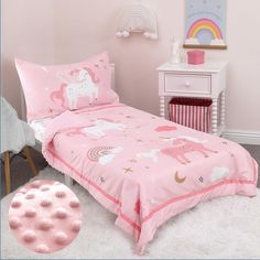 a child's bed with pink sheets and unicorns on it in a bedroom