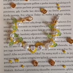 a book with some beads and charms on top of it, in front of an open page