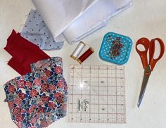 sewing supplies laid out on a table with scissors, fabric and other items to sew