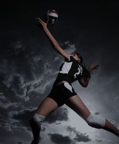 a woman jumping in the air to catch a volleyball