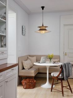 a living room filled with furniture and a laptop computer on top of a white table