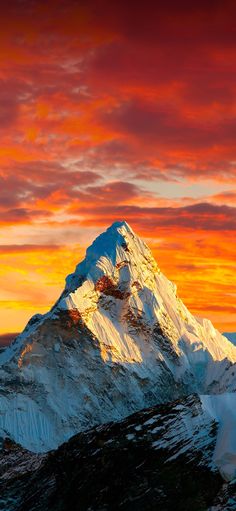 a snow covered mountain under a colorful sky