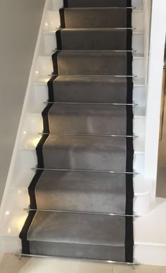 an image of a stair case with lights on the bottom and carpeted treads