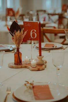 the table is set with place cards and candles