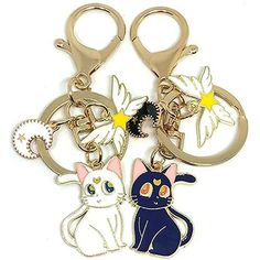 three key chains with two cats and one bird on each side, all in different colors