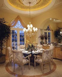 a fancy dining room with chandelier, table and chairs