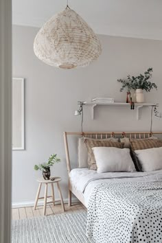 a bedroom with a bed, nightstand and hanging plant