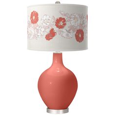 an orange lamp with white and red flowers on the fabric shade is sitting in front of a white background